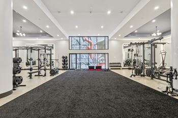 A spacious gym with a variety of equipment and a large mirror on the wall.